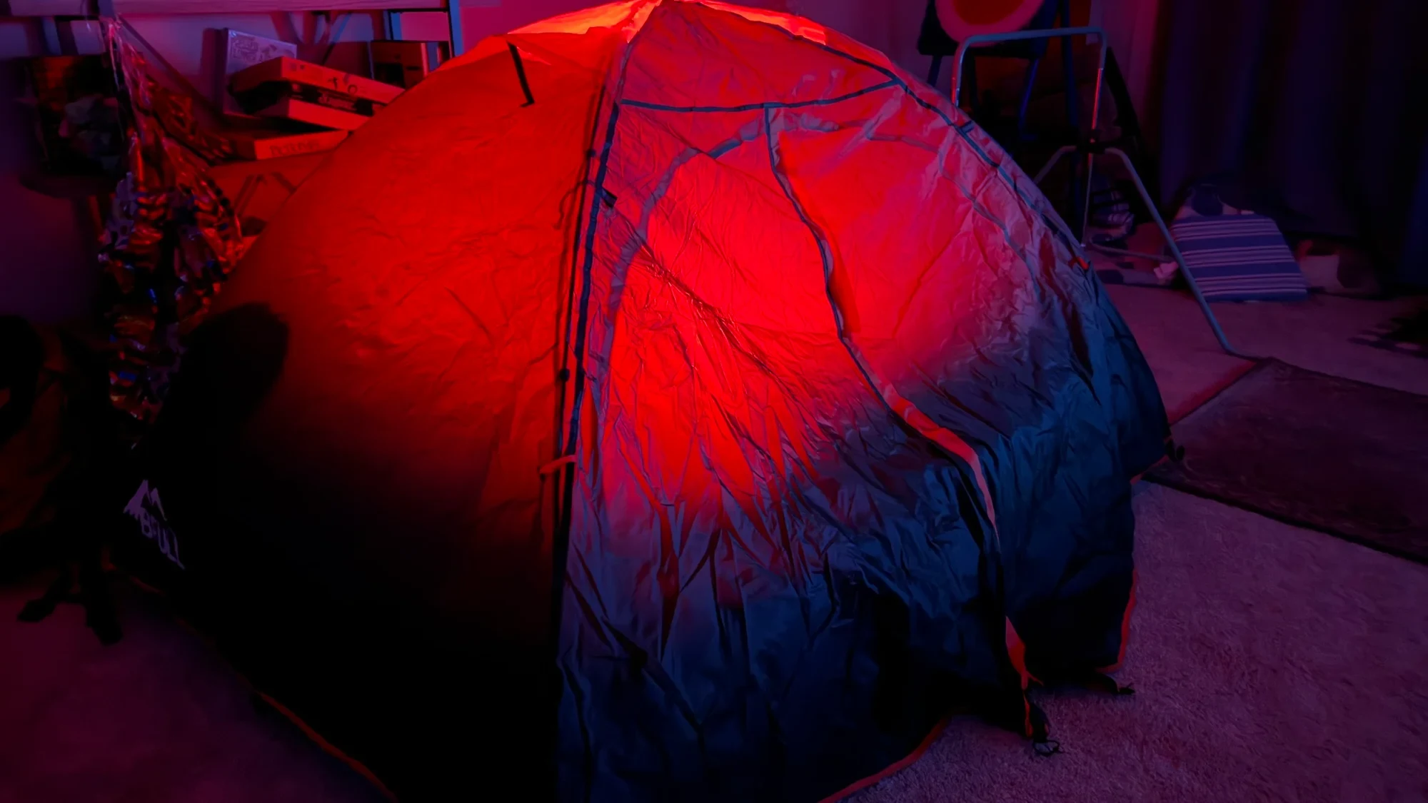 Indoor tent test showing red light glowing through the roof and walls. The light inside was pointed straight up.
